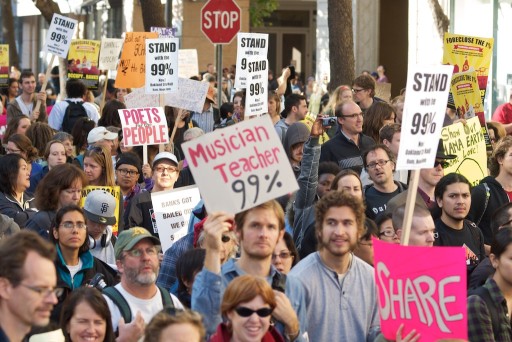 "Occupy Oakland 99 Percent signs" by Brian Sims - http://www.flickr.com/photos/briansims/6306751399/in/photostream/. Licensed under CC BY 2.0 via Wikimedia Commons "